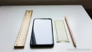 Ruler beside a smartphone and pencil, how long is 6 inches
